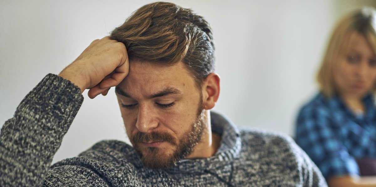 man looking sad while sitting with wife