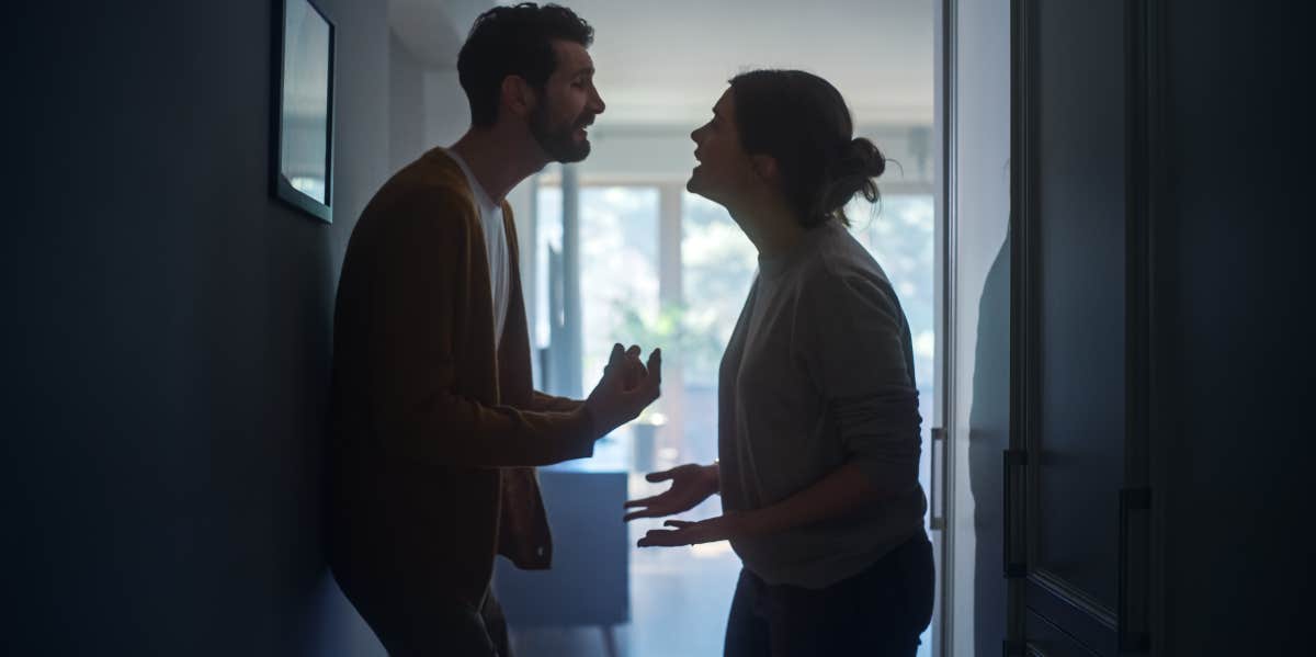 A man is arguing with a girl in a hallway