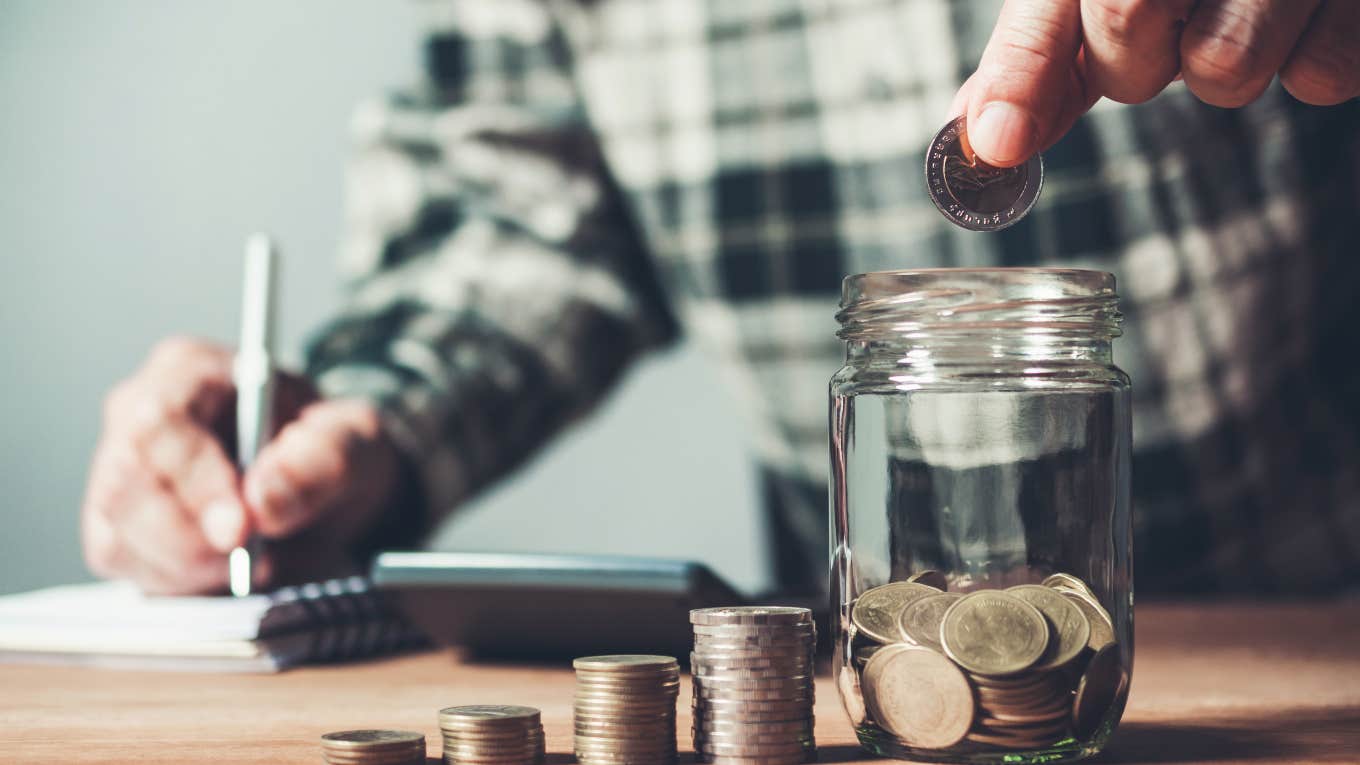 man counting money to put in jar to save