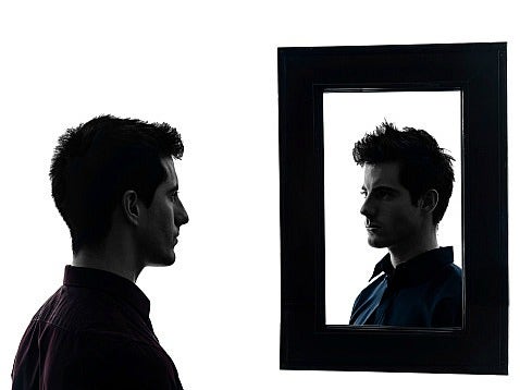 man looks in mirror