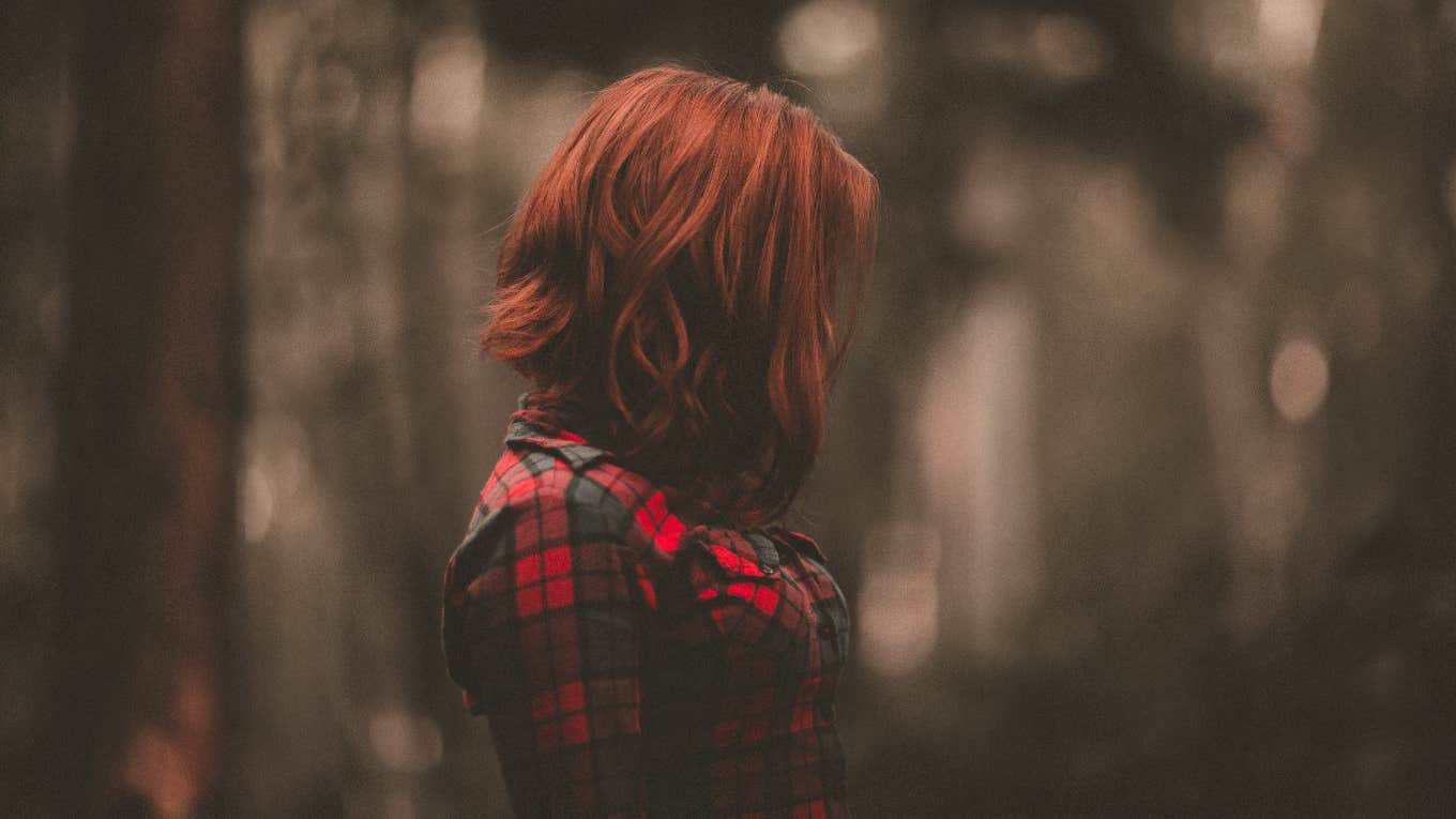 woman with red hair in the woods