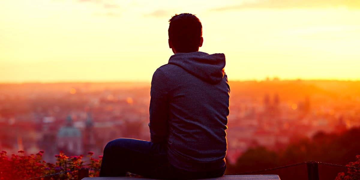 Man watching the sunrise over a city