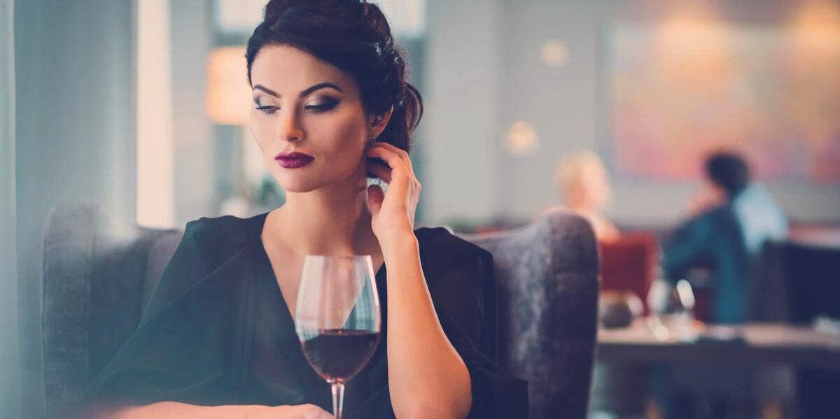 A Man Spots A Sad Woman Eating Alone At Restaurant & Offers To Pay For Her Meal But People Are Concerned woman with a wine glass alone
