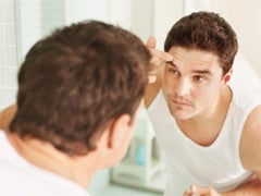 man primping in front of mirror
