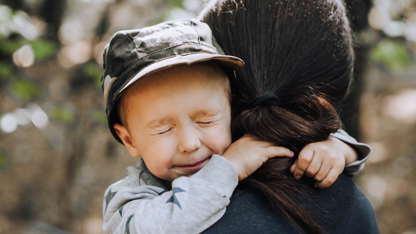 squinting boy hugging woman