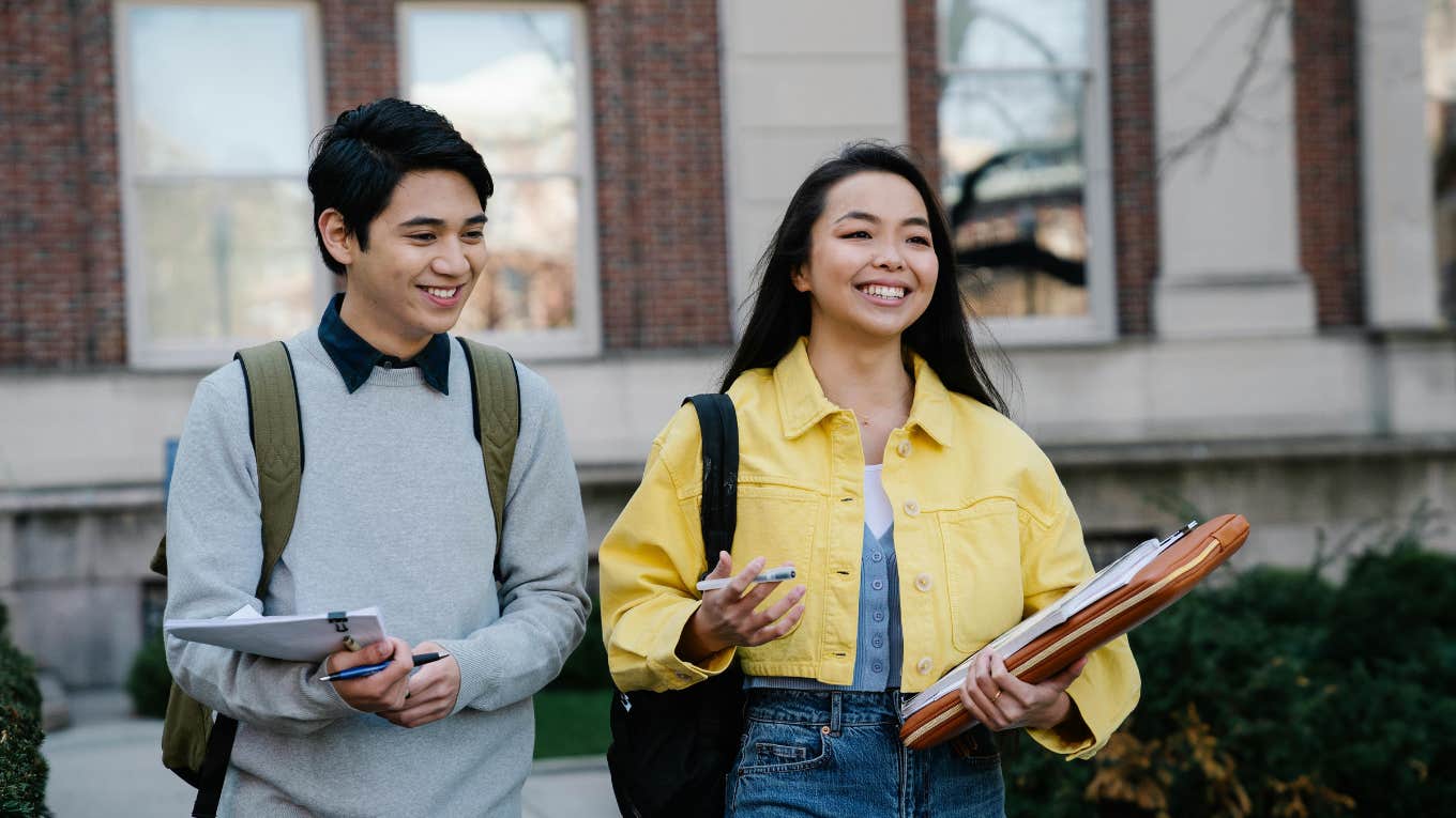 Young Man and Woman Walking Together On College Campus