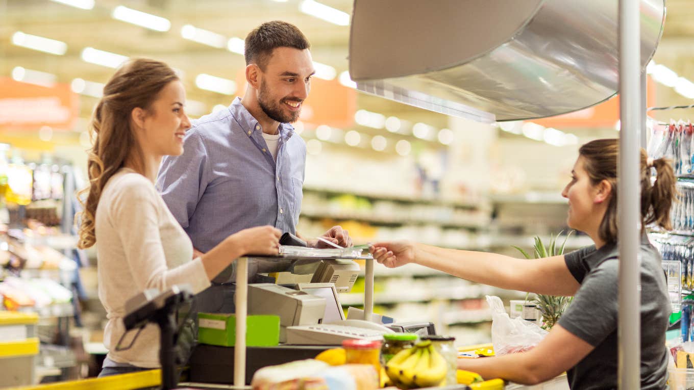 Customers talking to a grocery store cashier