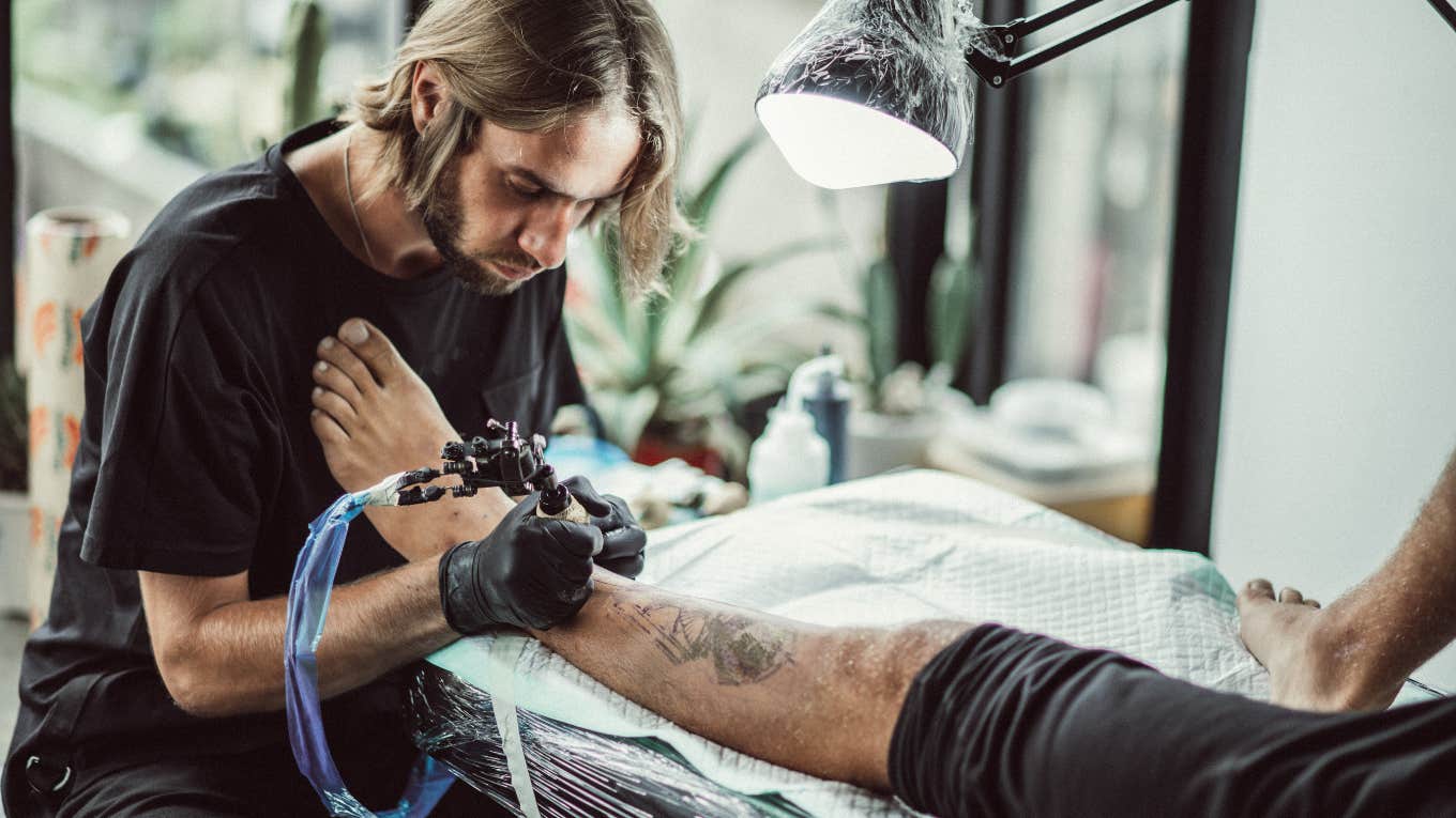man getting tattoo on leg