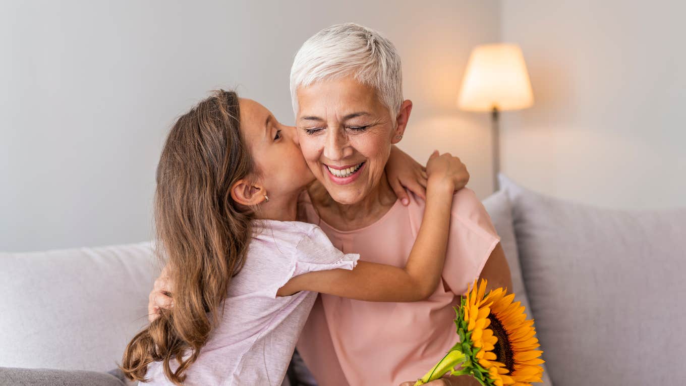 grandma hugging granddaughter thanking for gift and flowers