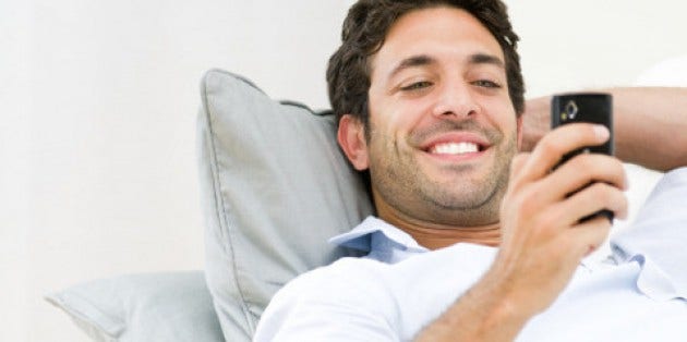 Man smiling while looking at the phone Man smiling while looking at the phone