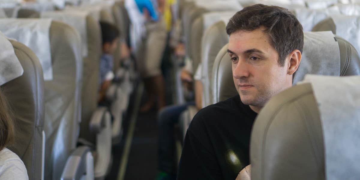 Man Complains About Dad Who Refused To Switch Seats With Him On Plane — Leaving Him Sitting Between Him & His Baby man sitting on an airplane