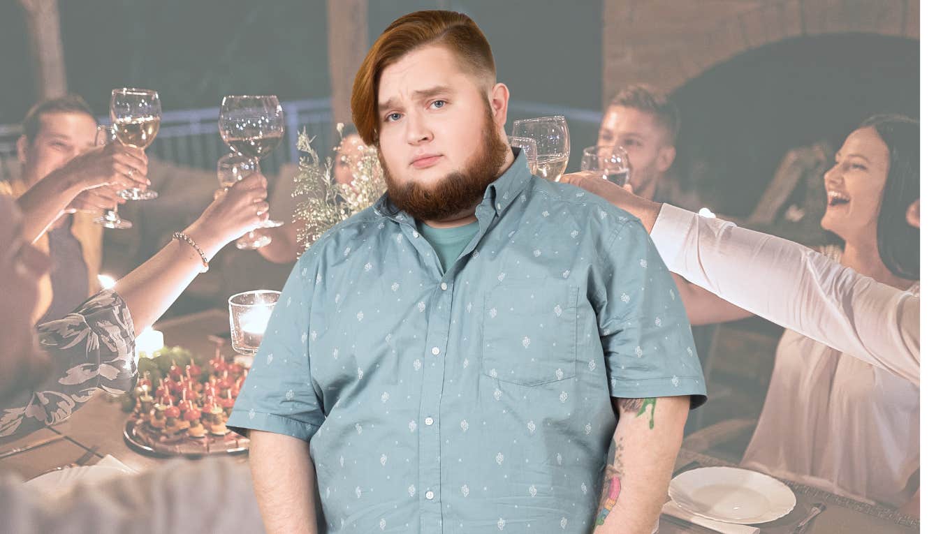 Man looking disappointed in front of a happy dinner party.