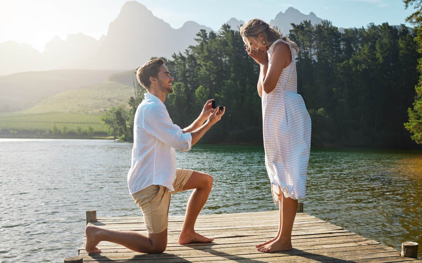 man proposing to woman on dock on lake