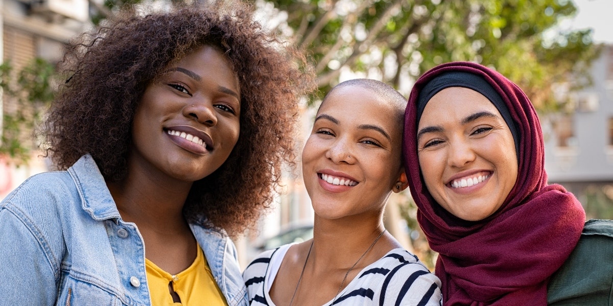 Three women hanging out together and smiling 