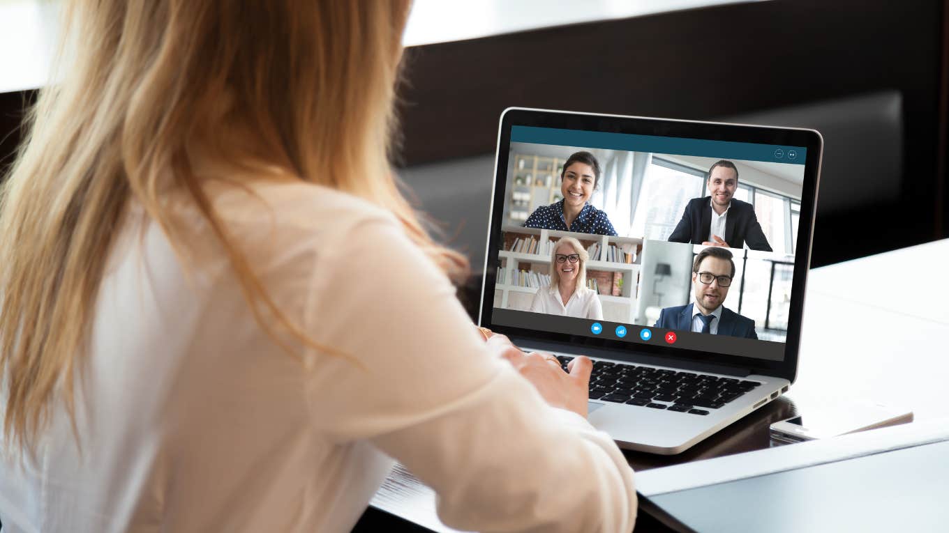 Back view of businesswoman speak using Webcam conference on laptop with diverse colleagues