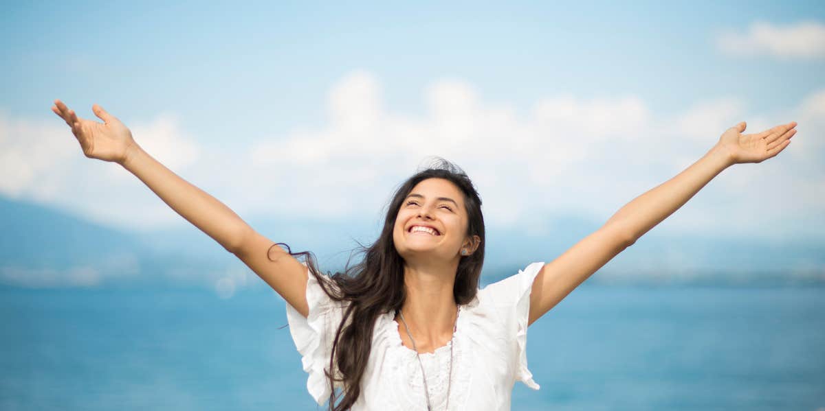 woman arms extended at beach