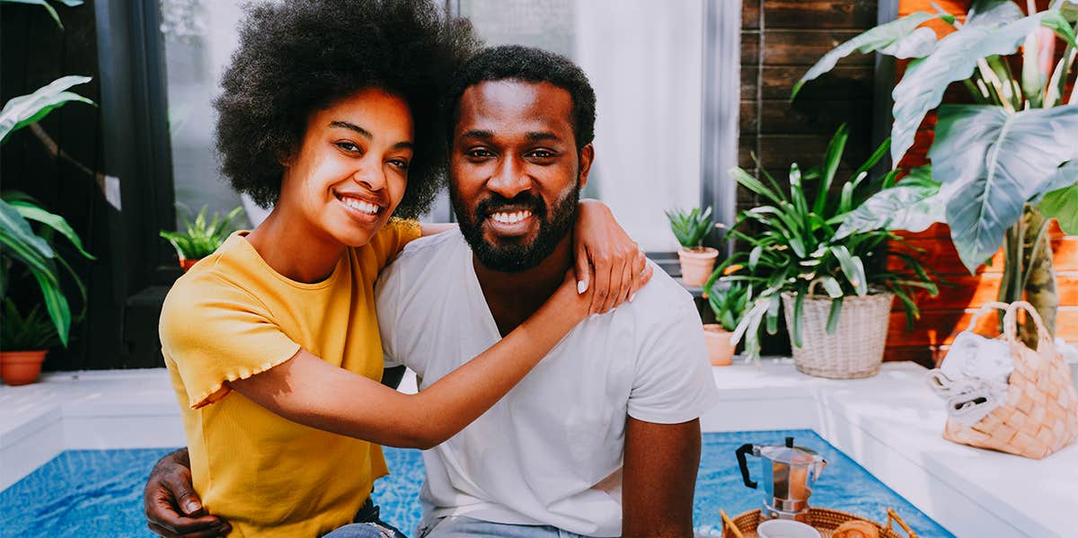 8 Unsexy Things Only The Happiest Married Couples Do woman hugging husband as they sit on their back porch