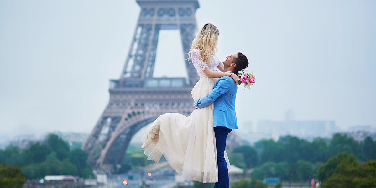 couple posing together in front of eiffel tower