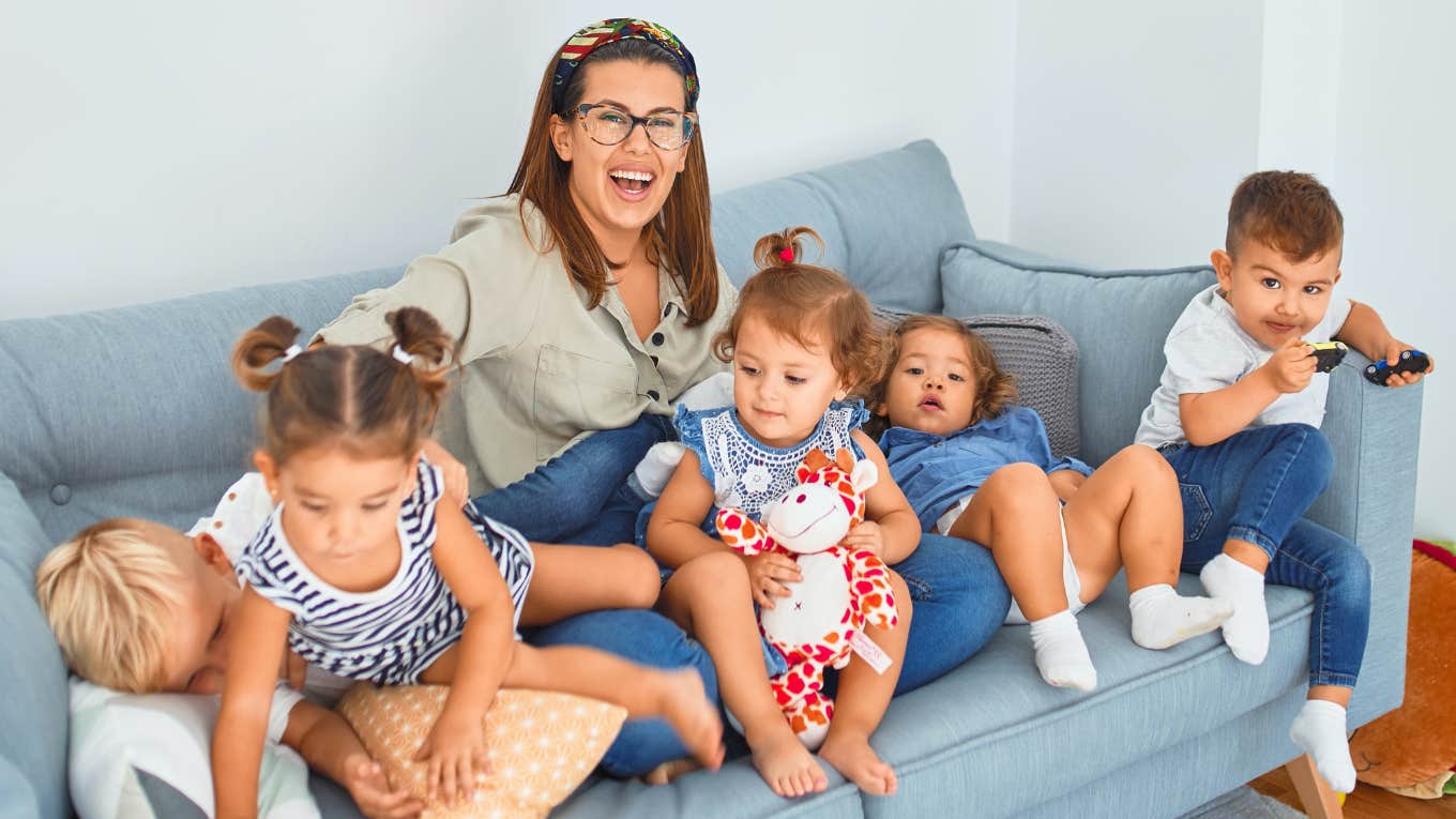 Married Couple Making $180,000 Have A Hard Time Making Ends Meet After Paying $80,000 A Year In Childcare woman sitting on couch with kids