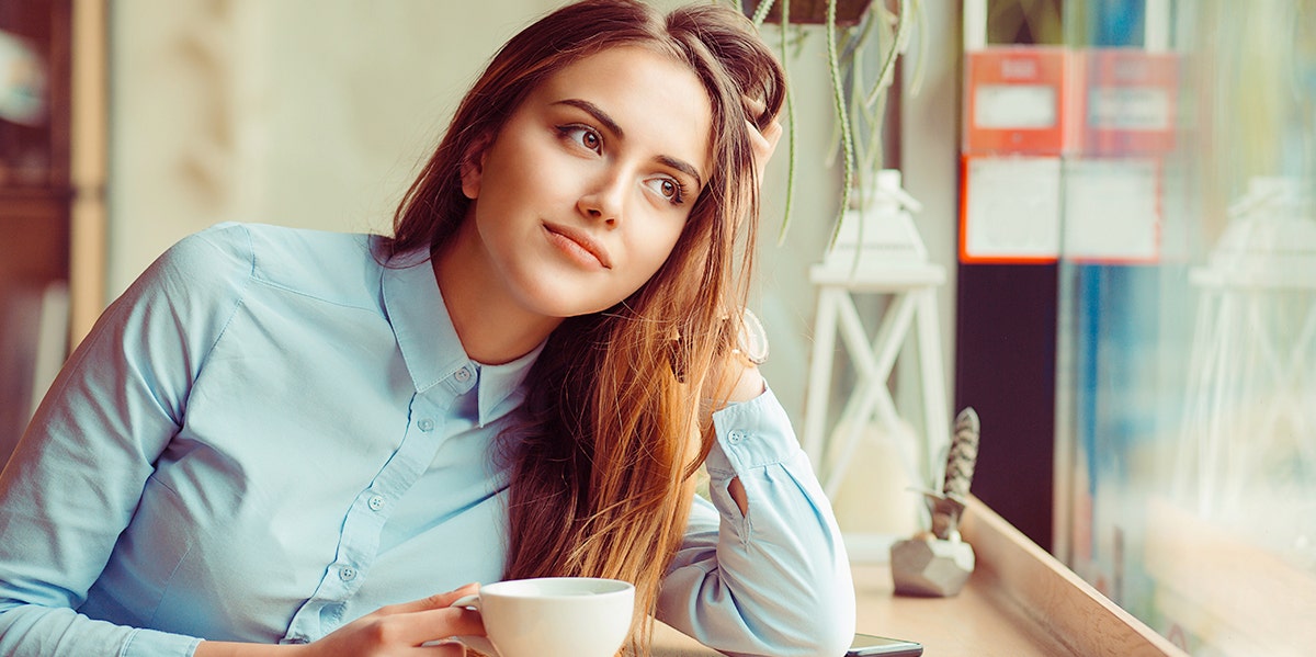 woman drinking coffee with hand in hair