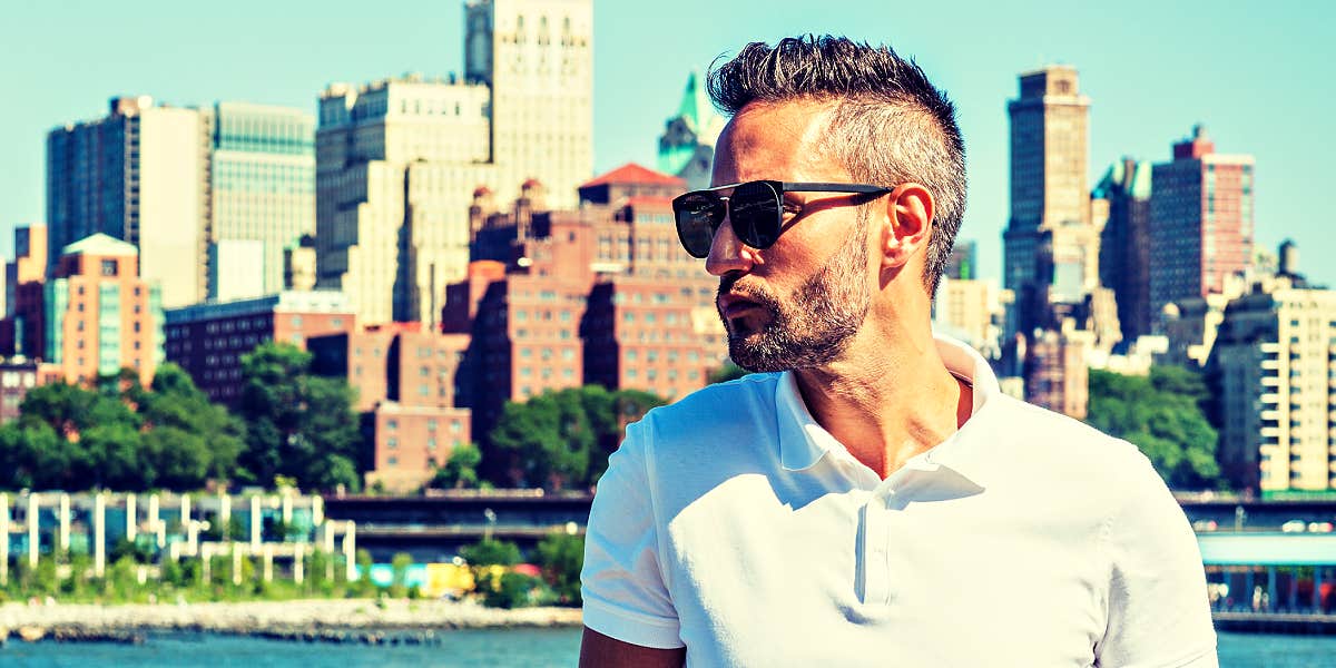 handsome man with grey hair against a city skyline 