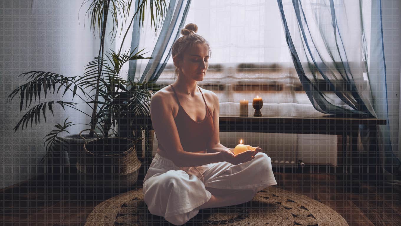 Woman lighting a candle, meditating 