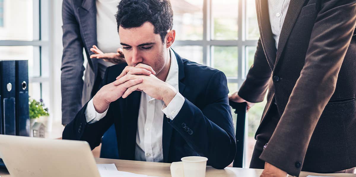 man at the computer with boss standing over him