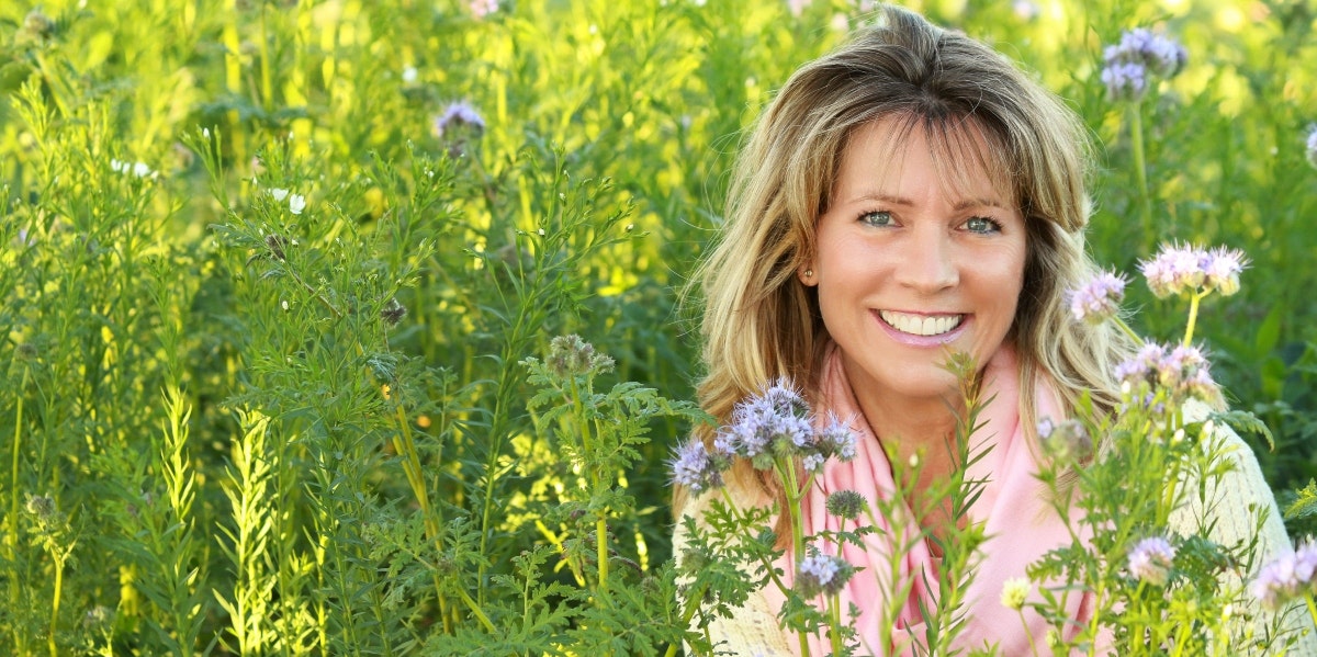 smiling woman surrounded by tall grass