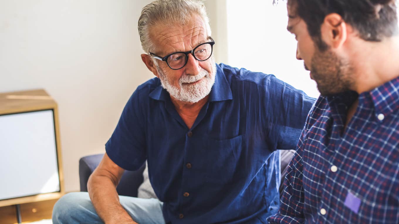 dad and son having discussion on couch at home