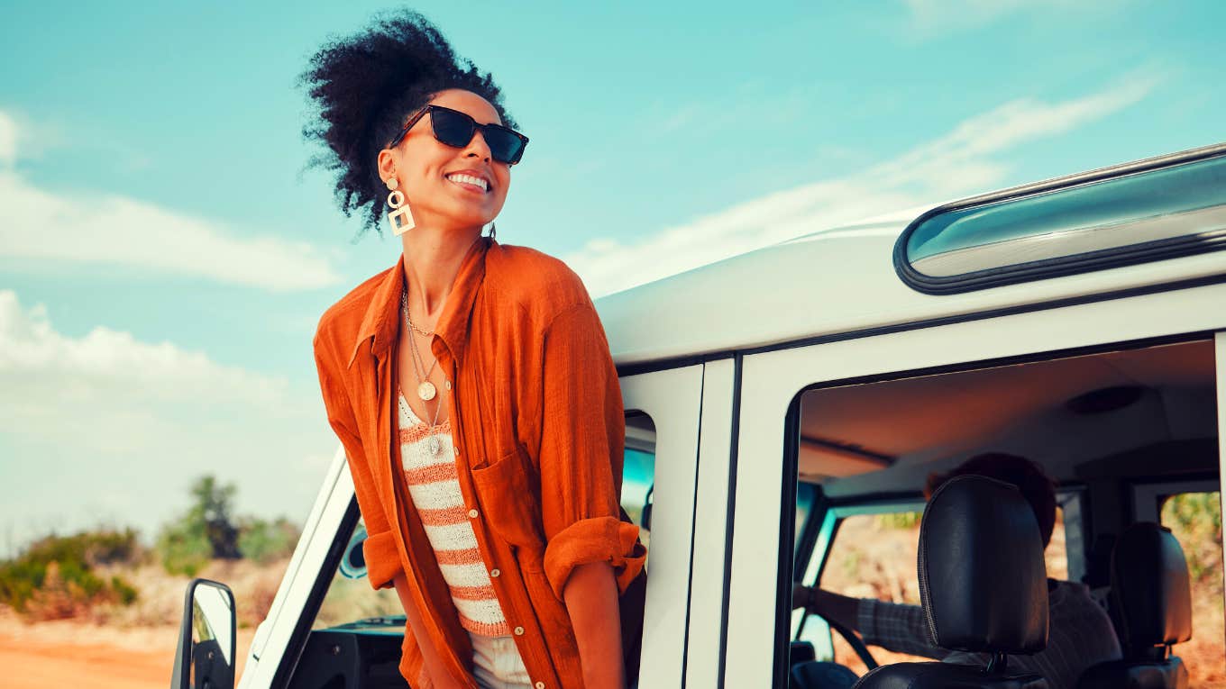 woman enjoying window view of desert and traveling in a van