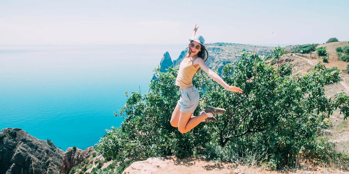 How I Found Joy By Embracing A Minimalist Lifestyle woman jumping on mountain