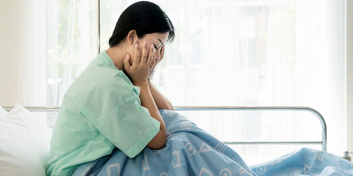 woman crying in hospital bed