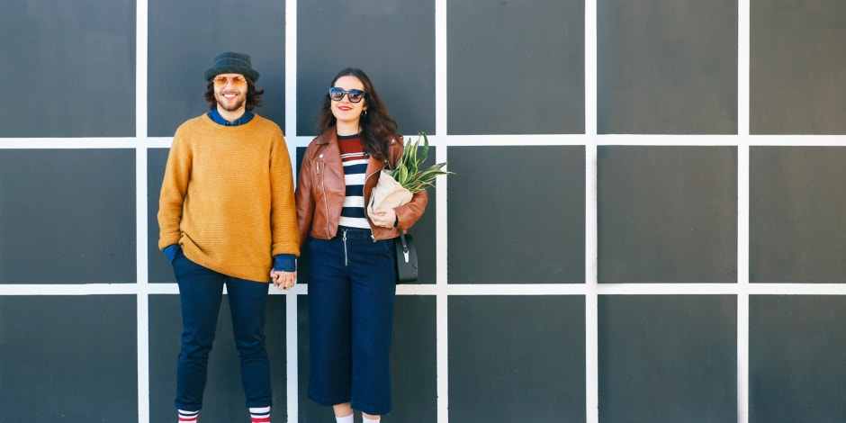 man and woman standing against striped background