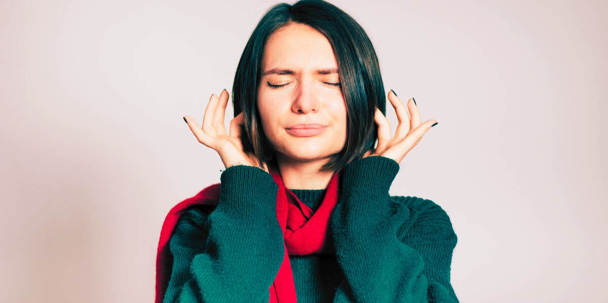 woman covering her ears