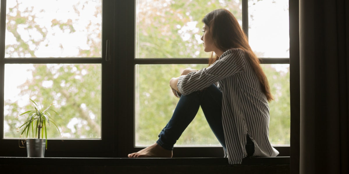 woman looking out the window sad