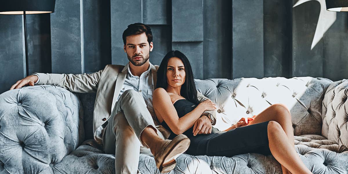 young fashionable couple on a modern sofa looking serious