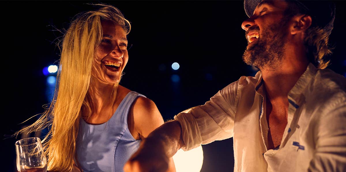 Author Of "Men Are From Mars, Women Are From Venus" Provides Modern-Day Update man and woman enjoying drinks at night laughing together