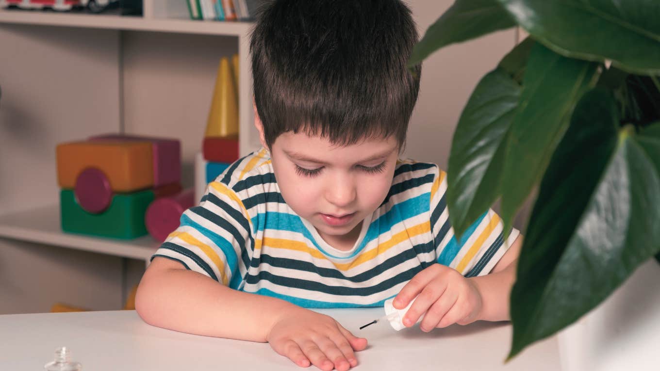 little boy applying nail polish