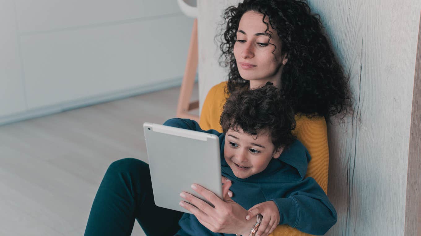 mom and son on the floor playing on a tablet