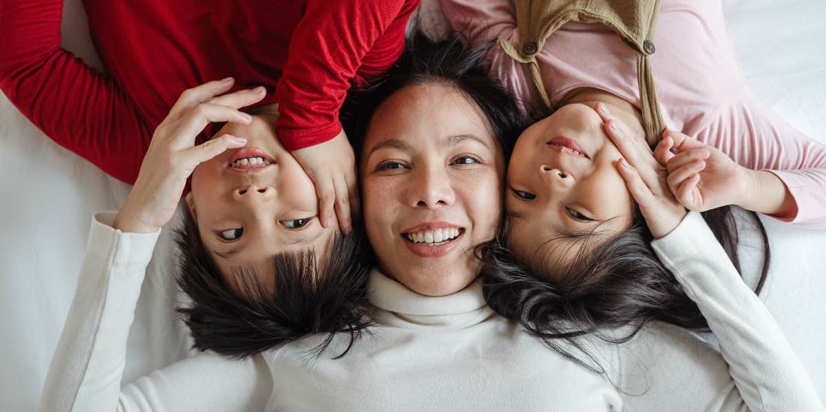 Mom and two kids lying on bed