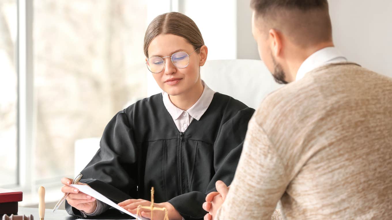 Judge sitting down with a man looking at papers. 