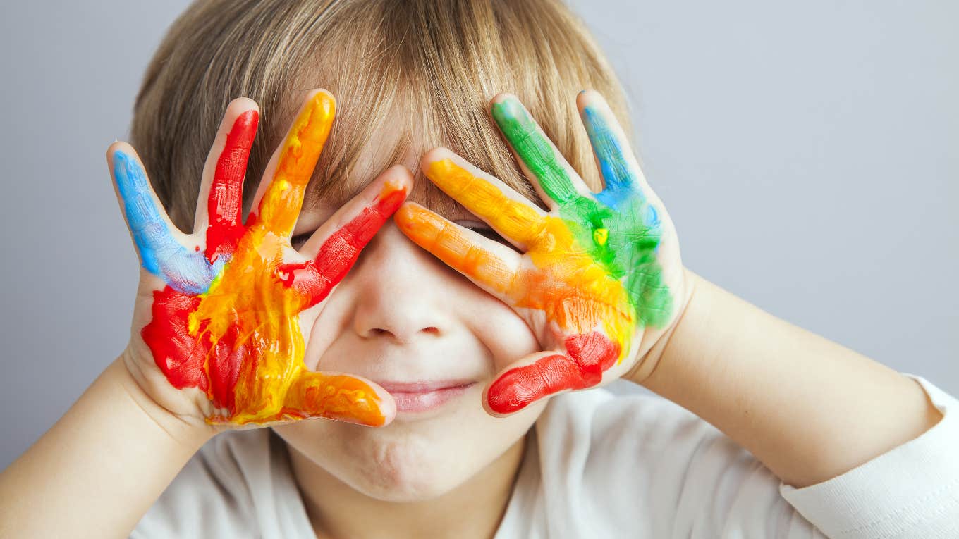 young boy with paint on the palms of his hands