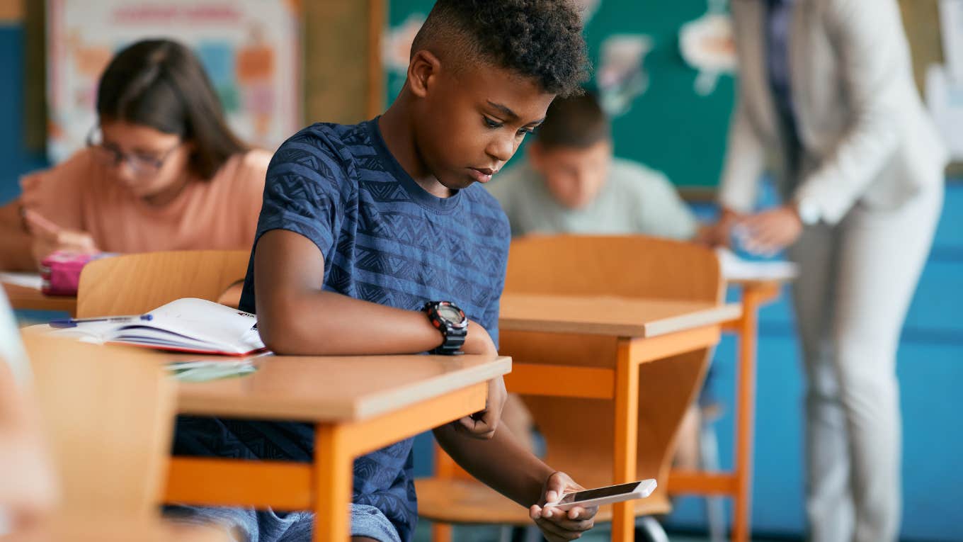 Teacher Takes A Student's Phone Home & His Mom Shows Up To Take It Back boy on phone in class
