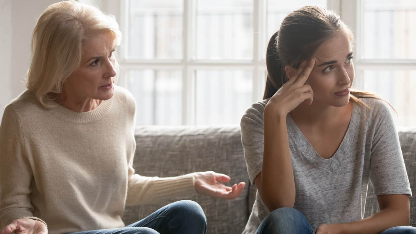 annoyed mother and daughter sitting on couch having a fight