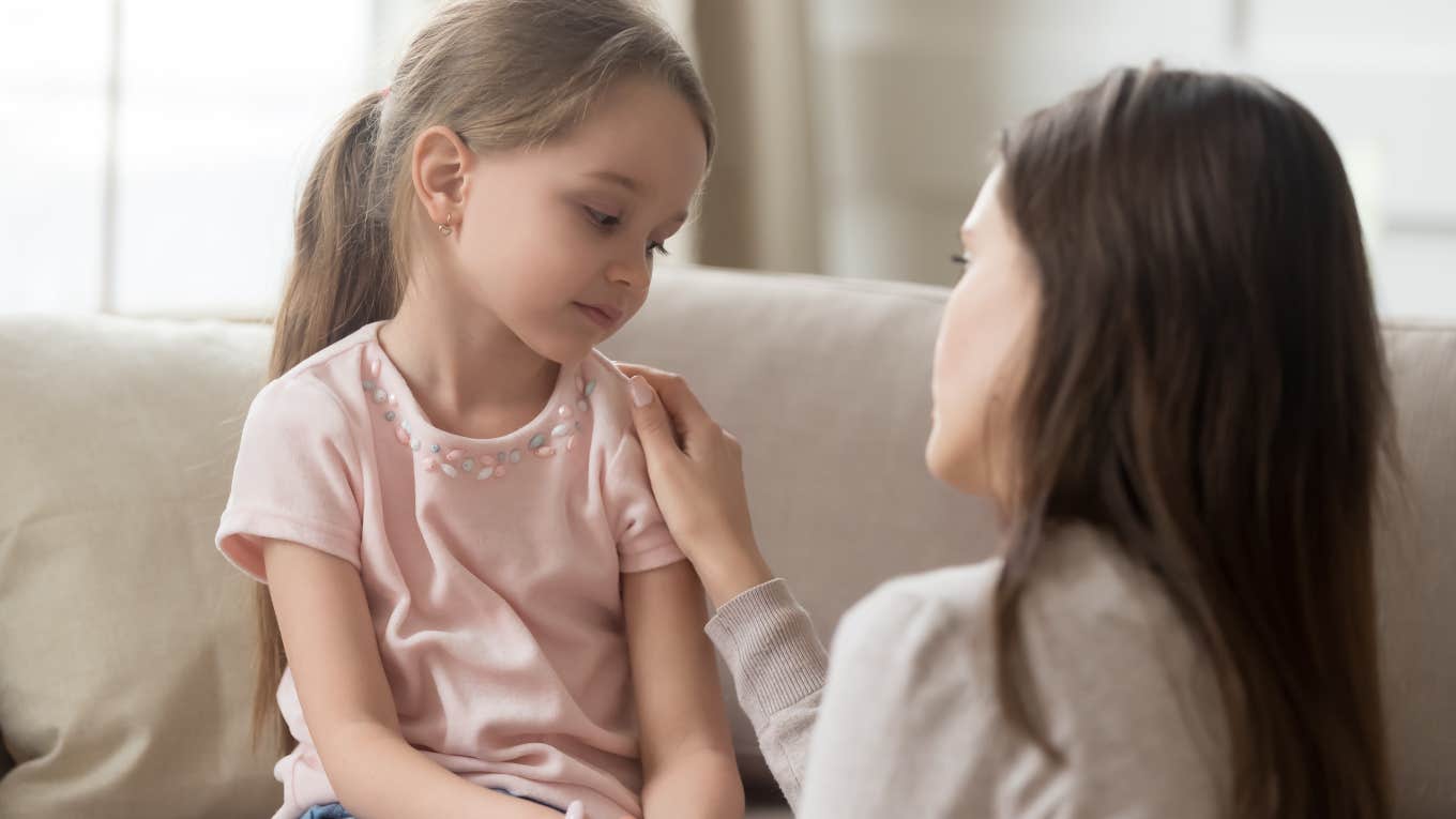 mom consoling upset daughter and touching her shoulder