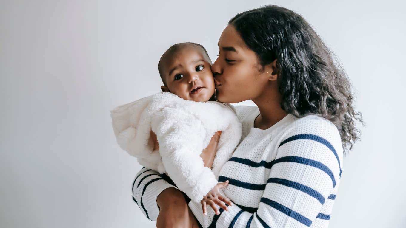 mom kissing the cheek of her infant baby