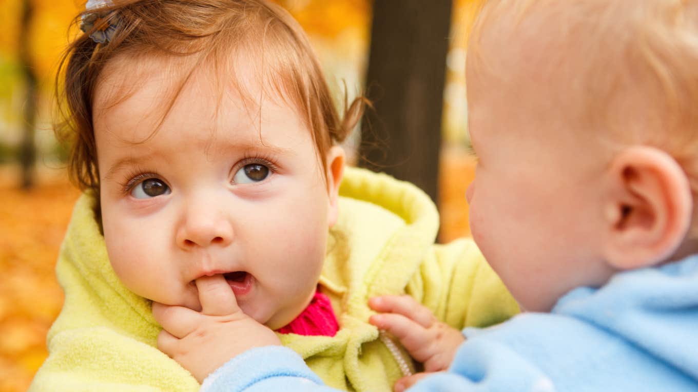 two toddlers, bite finger