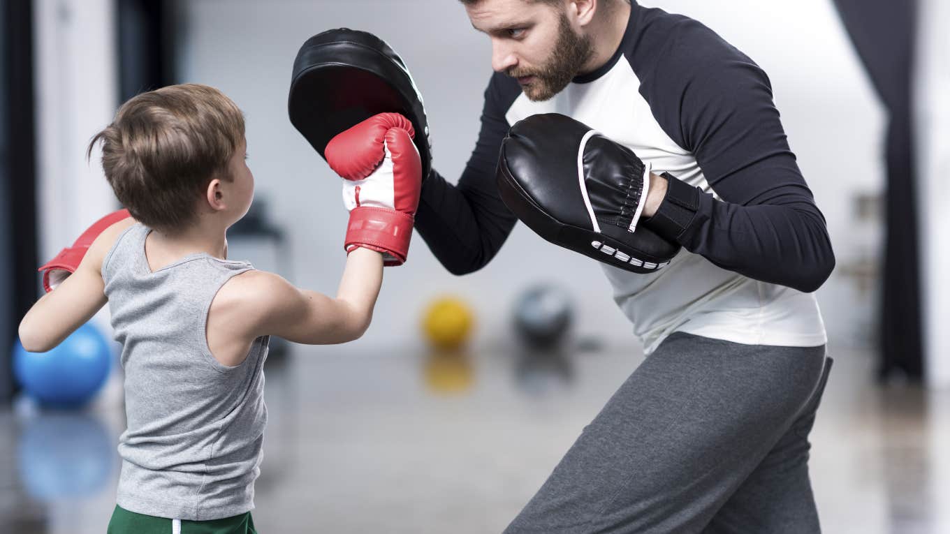 man teaching little boy how to box