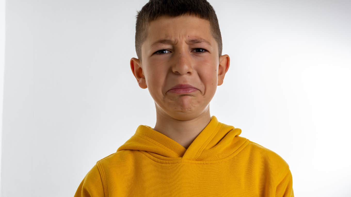 sad little boy in yellow sweatshirt