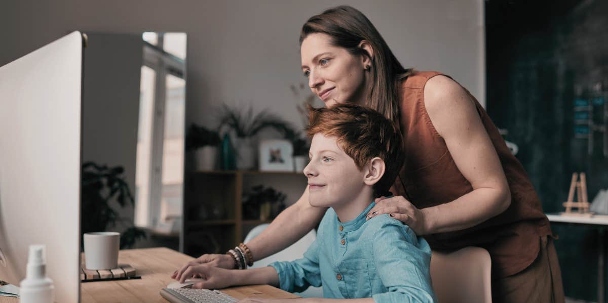 mom helping son on computer